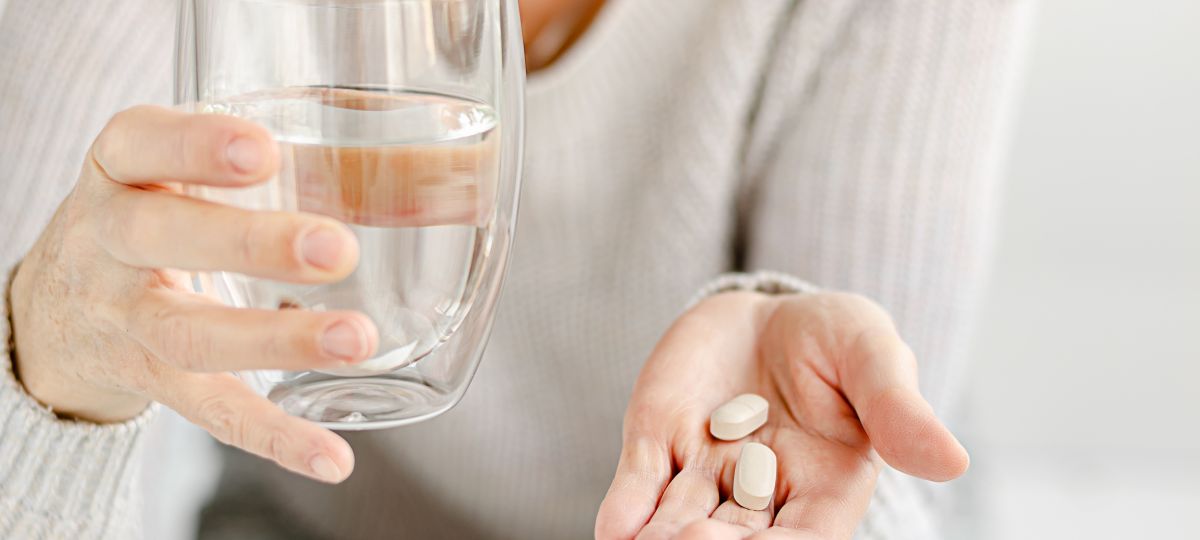 woman holding multivitamin in hand